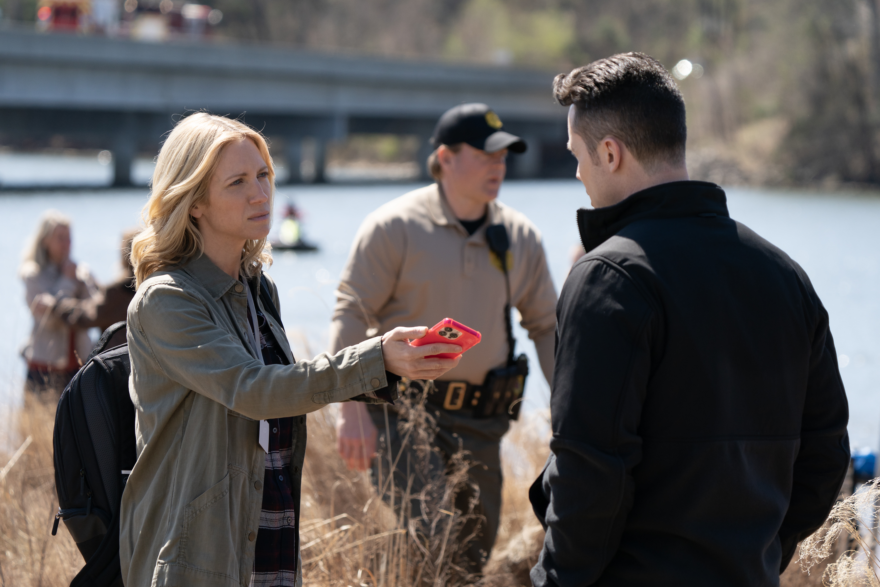 brittany snow as mandy matney handing a business card to a man by a body of water murdaugh death in the family