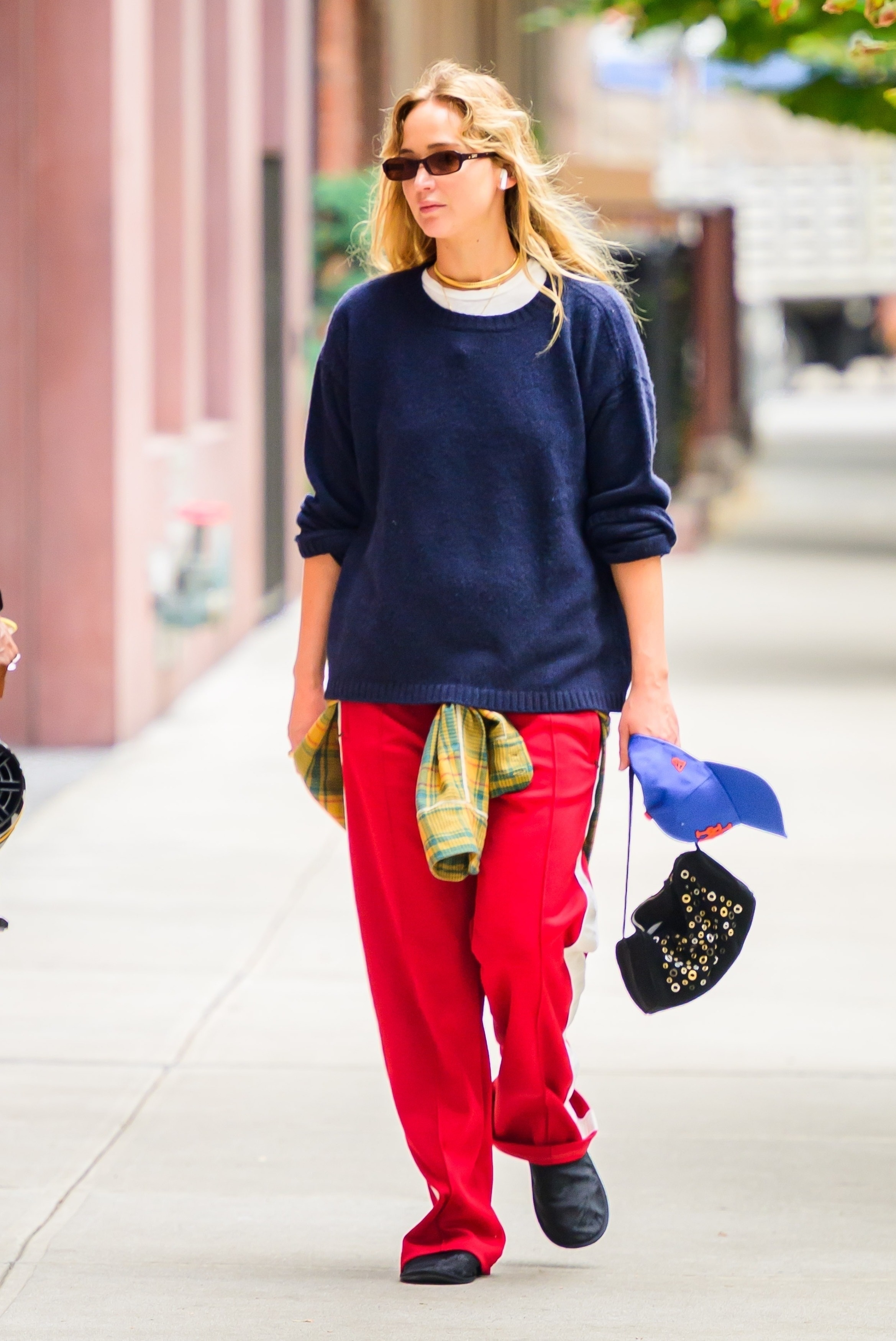 Jennifer Lawrence was spotted heading to the gym early in the morning in Los Angeles wearing red track pants, a grommet shoulder bag, and a pair of leather flats from The Row.