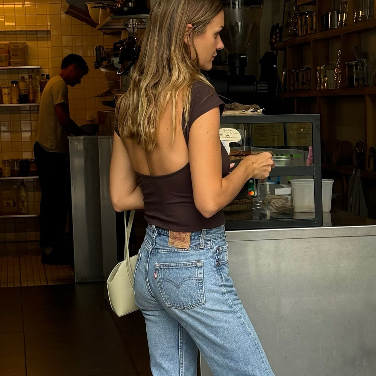 Woman in brown top and straight-leg jeans