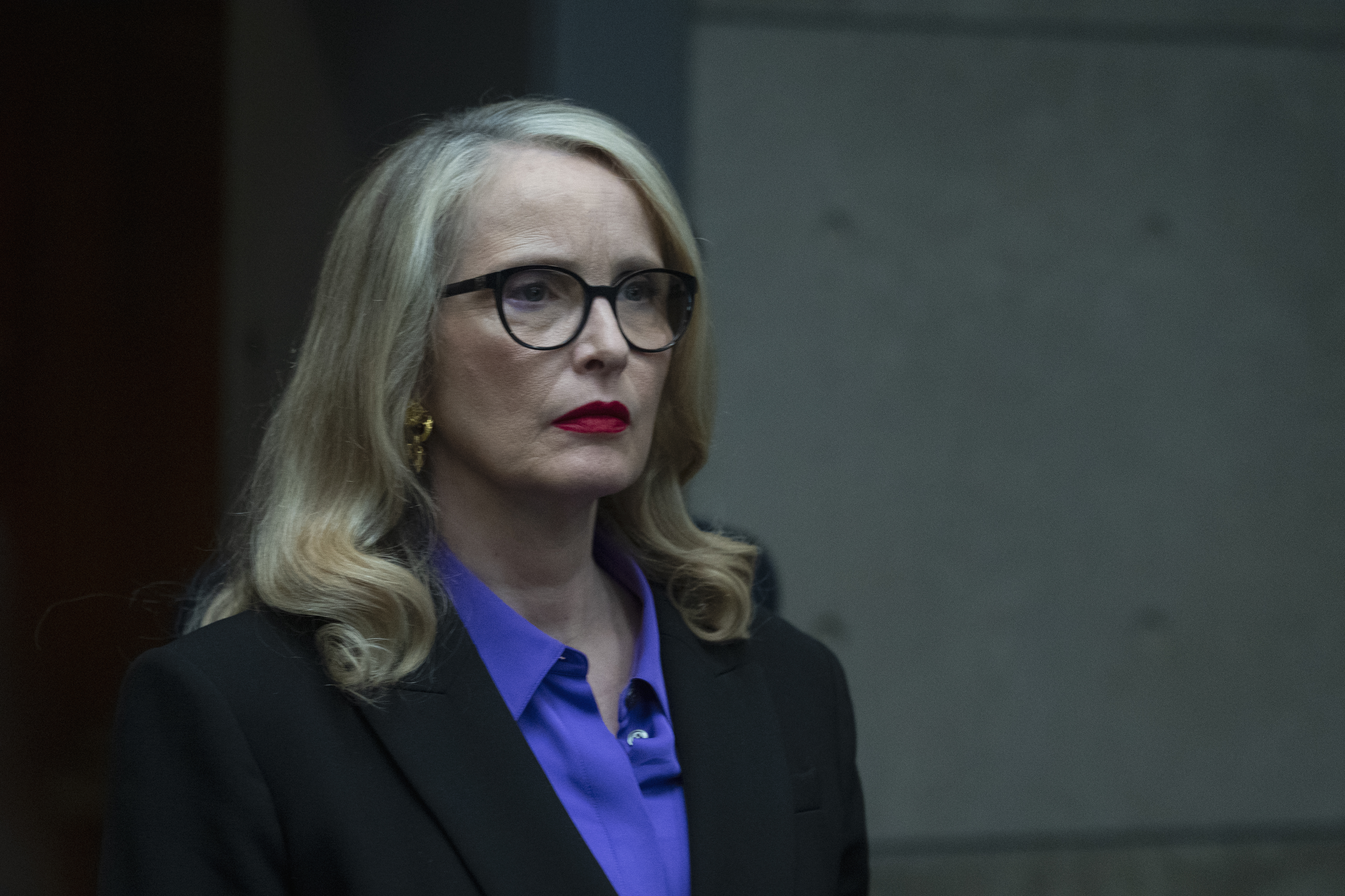 julie delpy as vivienne wearing a black blazer glasses and blue shirt in hostage