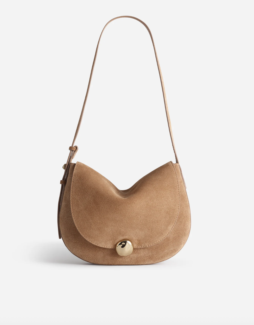 a madewell suede bag in front of a plain backdrop