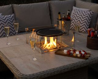 fire pit table with grilling accessory from bramblecrest