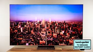 The TCL QM8L displaying a city skyline alongside a badge that reads: "Tom's Guide TV Brand Report Card"