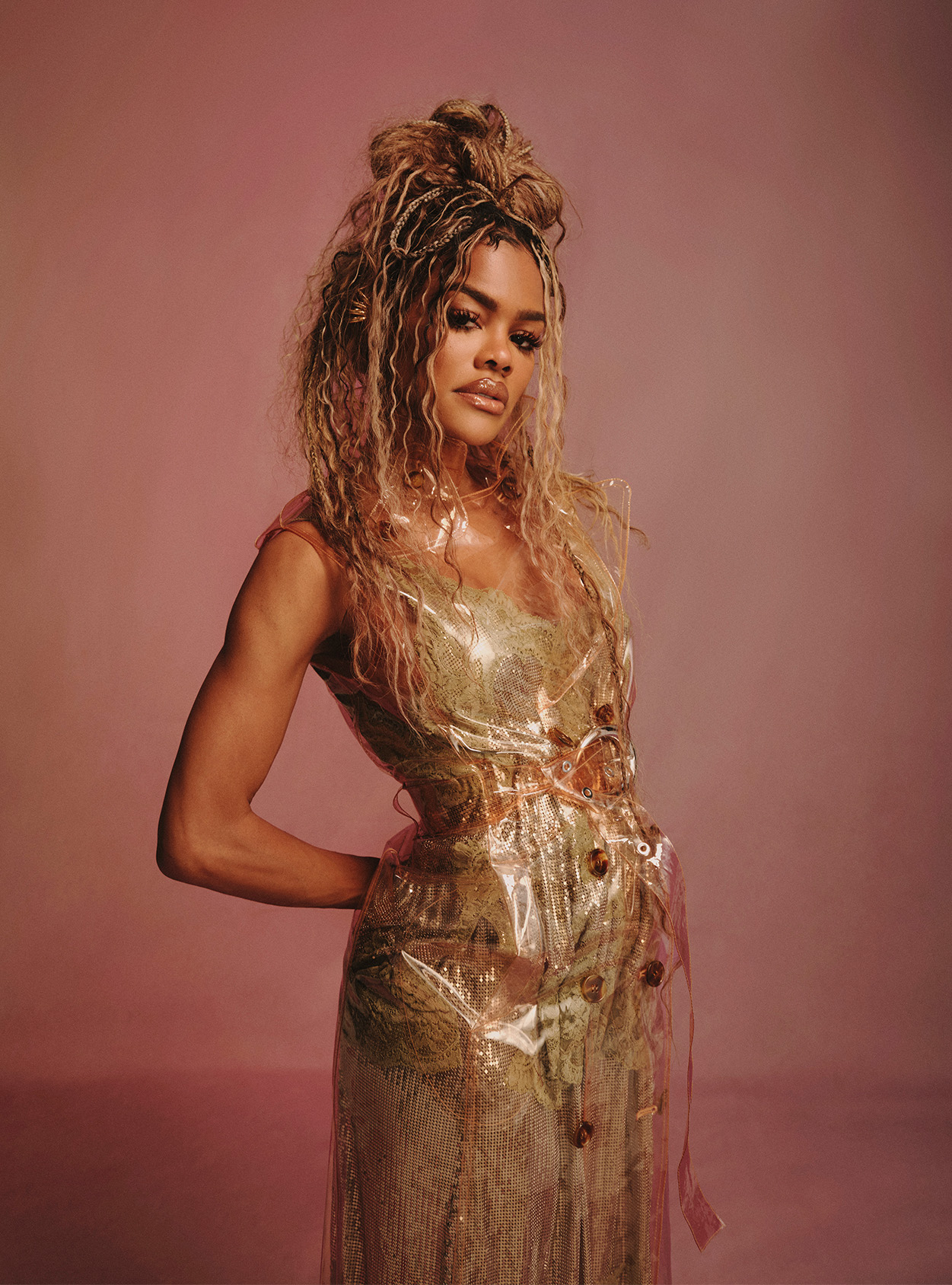 Teyana Taylor wearing a nude dress with her hands on her hips