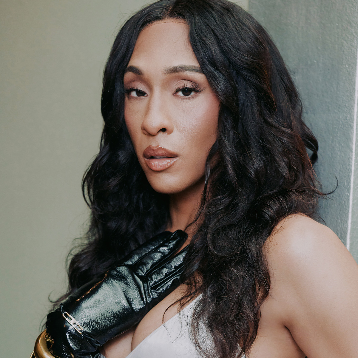 headshot of michaela jae rodriguez wearing a black glove and holding it to her chest