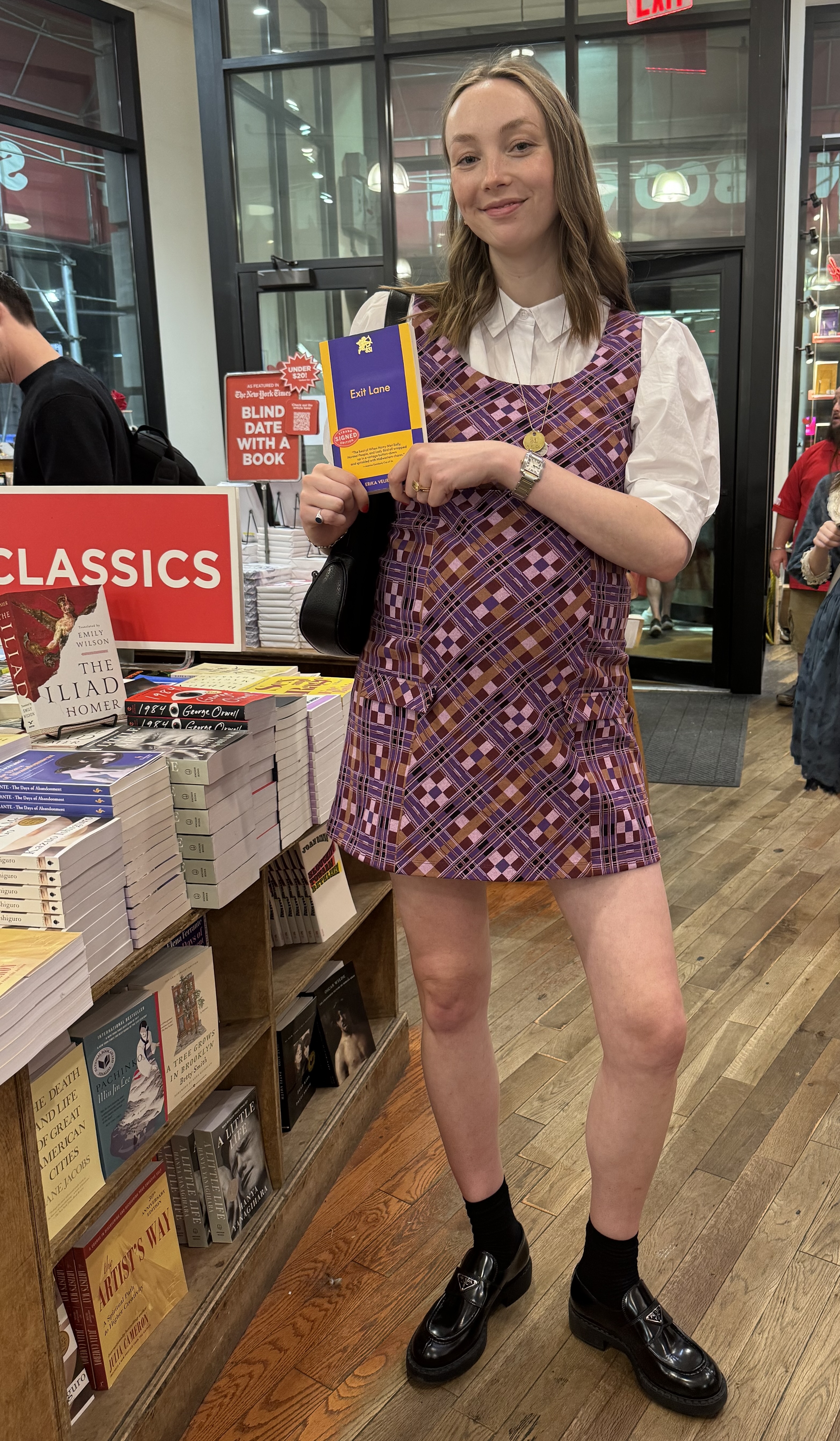 Erika Veurink wearing a printed mini dress over a white button-up short and black loafers