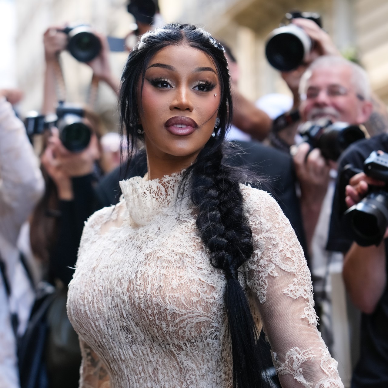 cardi b standing in front of a crowd of paparazzi