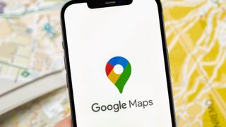 Google Maps logo on phone with map in background