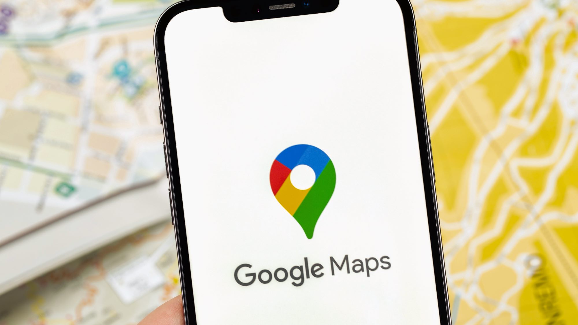 Google Maps logo on phone with map in background