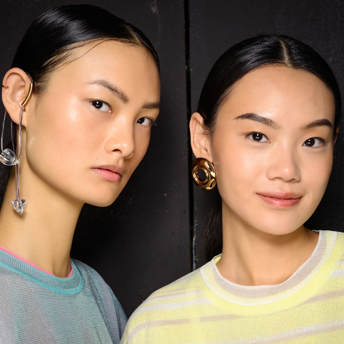 two asian women facing the camera with glowing skin from using retinol eye creams in pastel sweaters