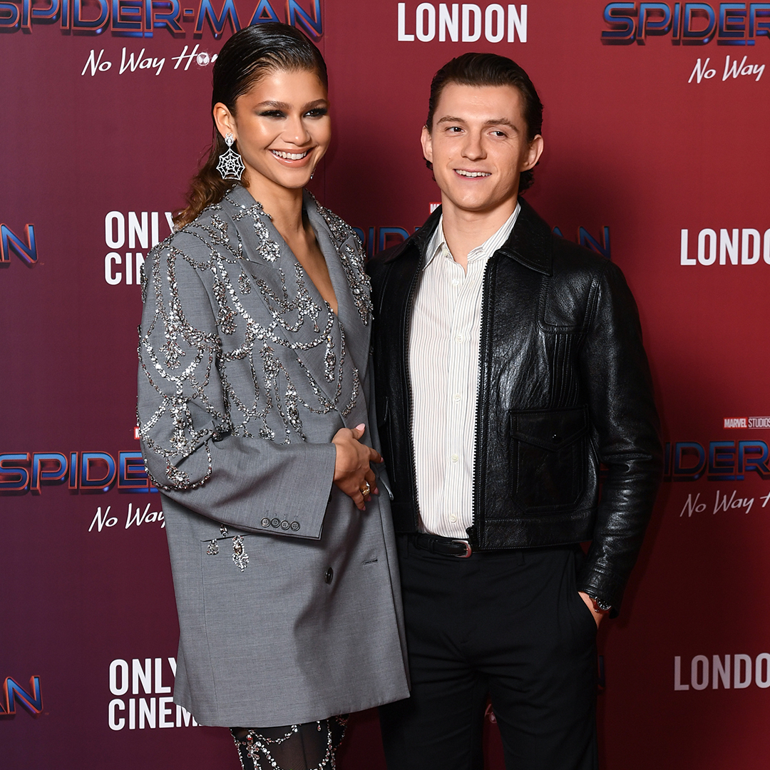 Zendaya wearing a gray embellished blazer and Tom Holland wearing a stripped white shirt and black leather jacket at a photocall for 'Spiderman: No Way Home' at The Old Sessions House on December 05, 2021 in London, England