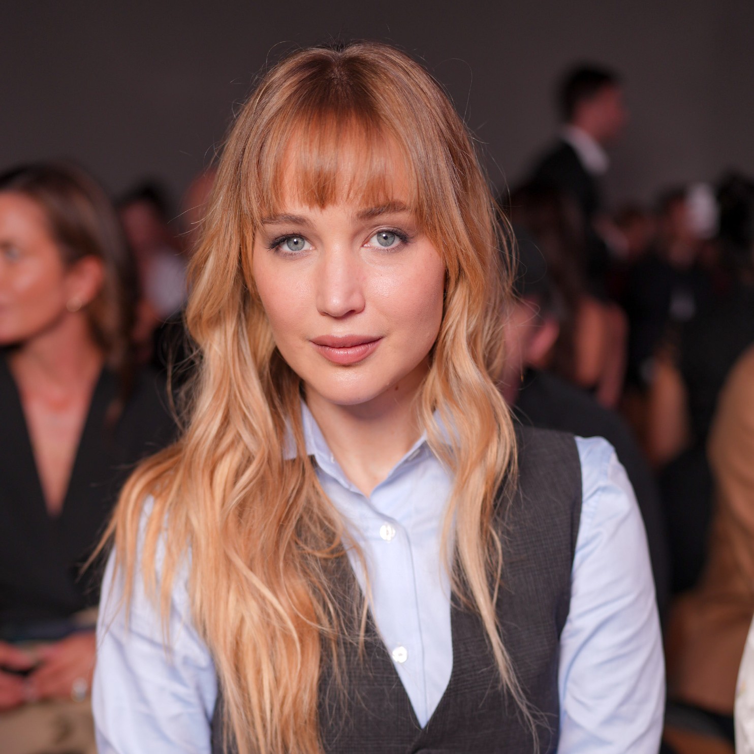 a white woman with dark blonde hair sitting front row at a fashion show