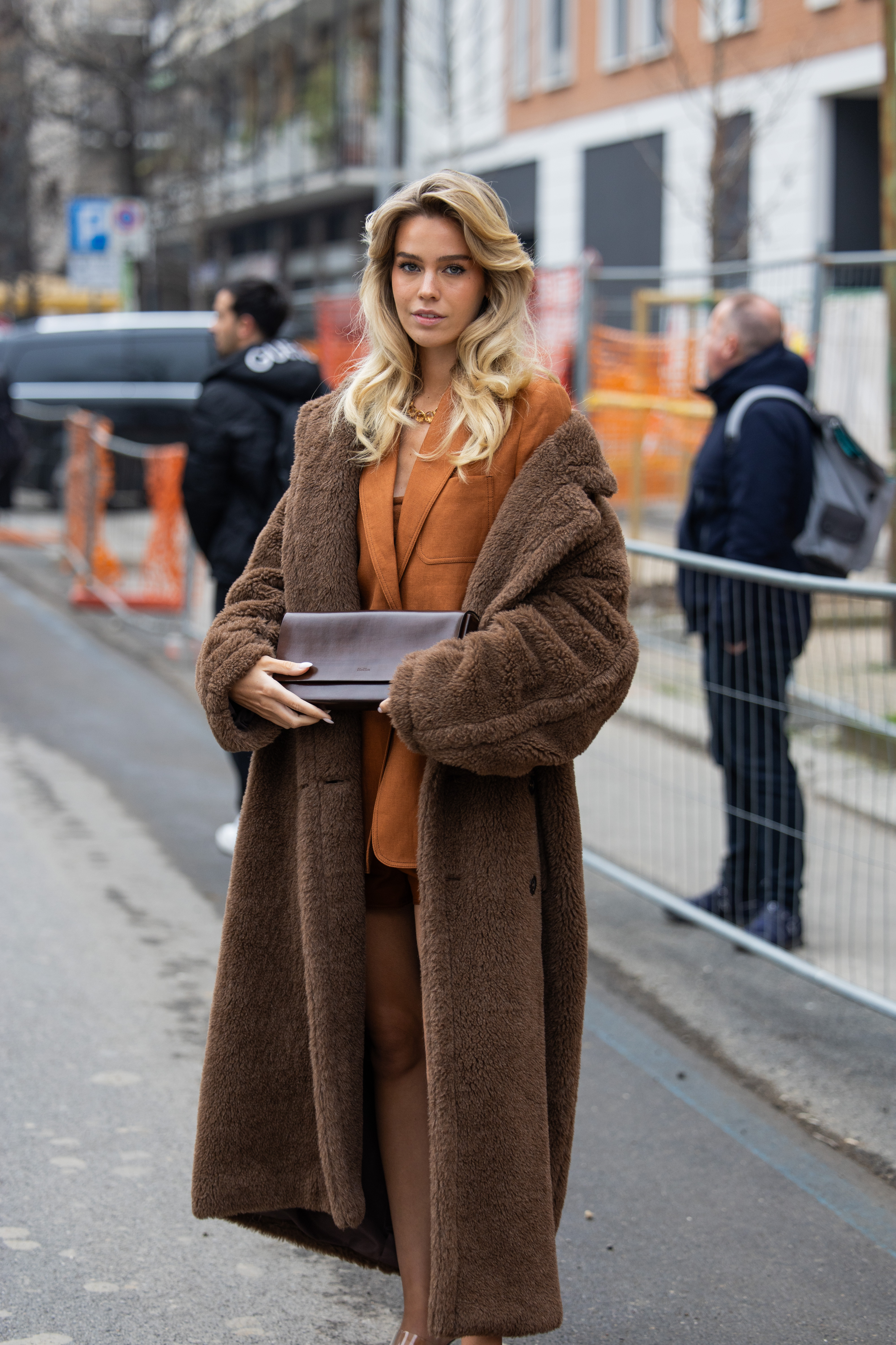 woman wearing a teddy coat and an orange blazer