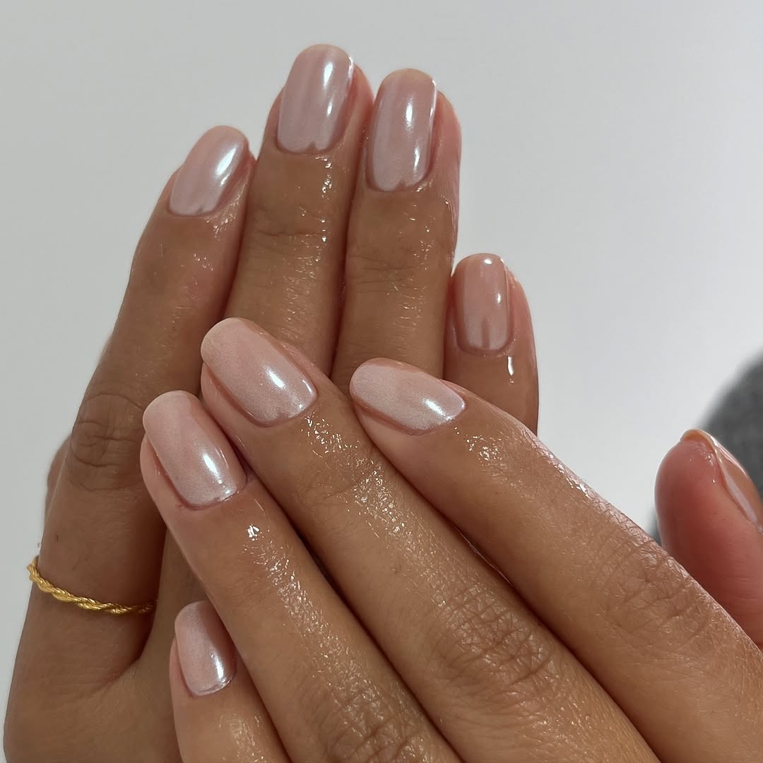 a person wearing a light brown manicure with a chrome overlay