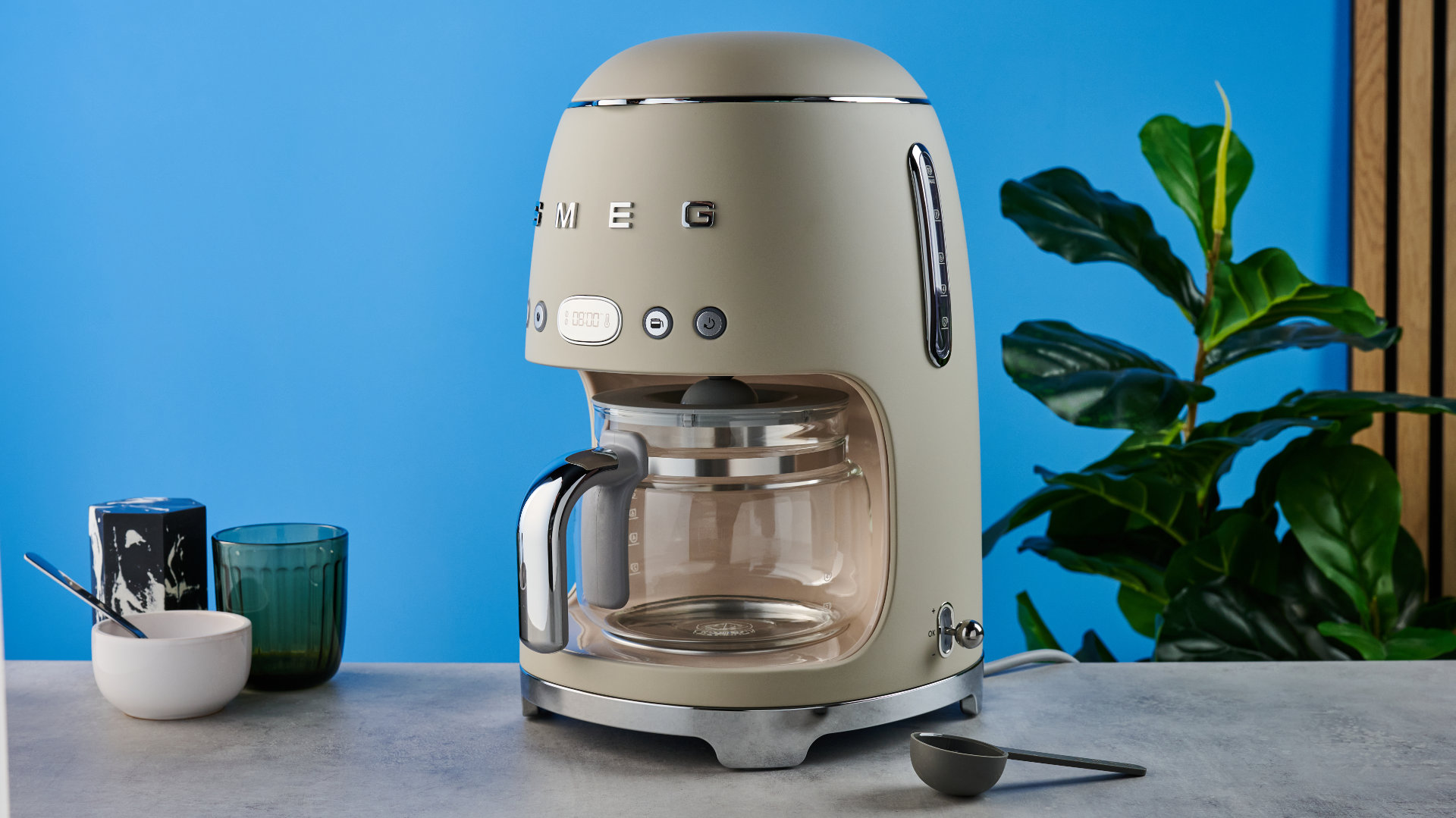the smeg retro coffee maker photographed against the blue tom's guide background