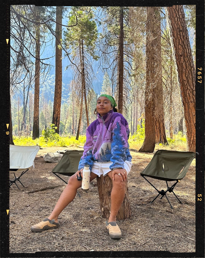 Evelynn Escobar sitting on a camping chair in the forest