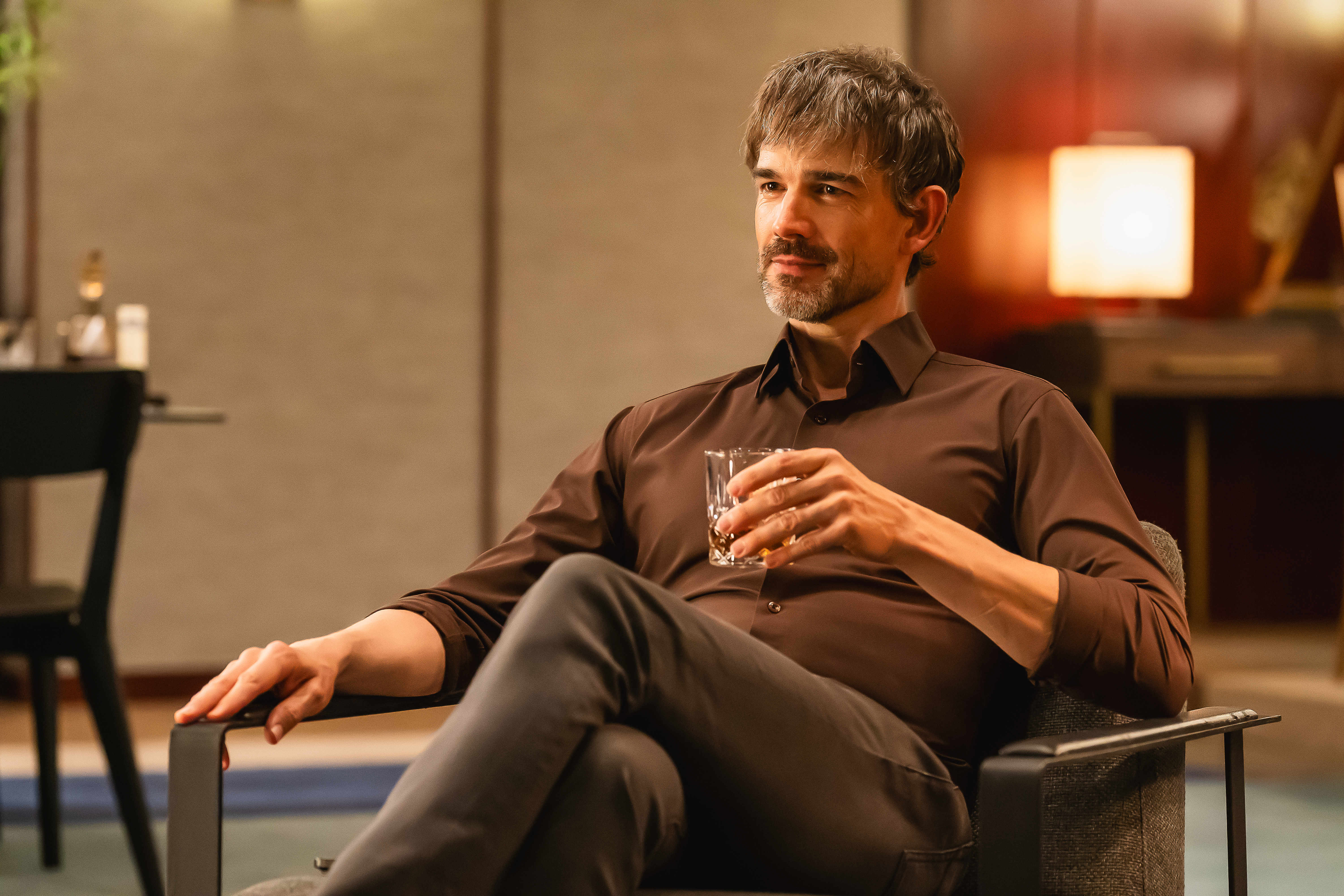 Christopher Gorham holds a drink and sits in a chair in 'Tempest.'
