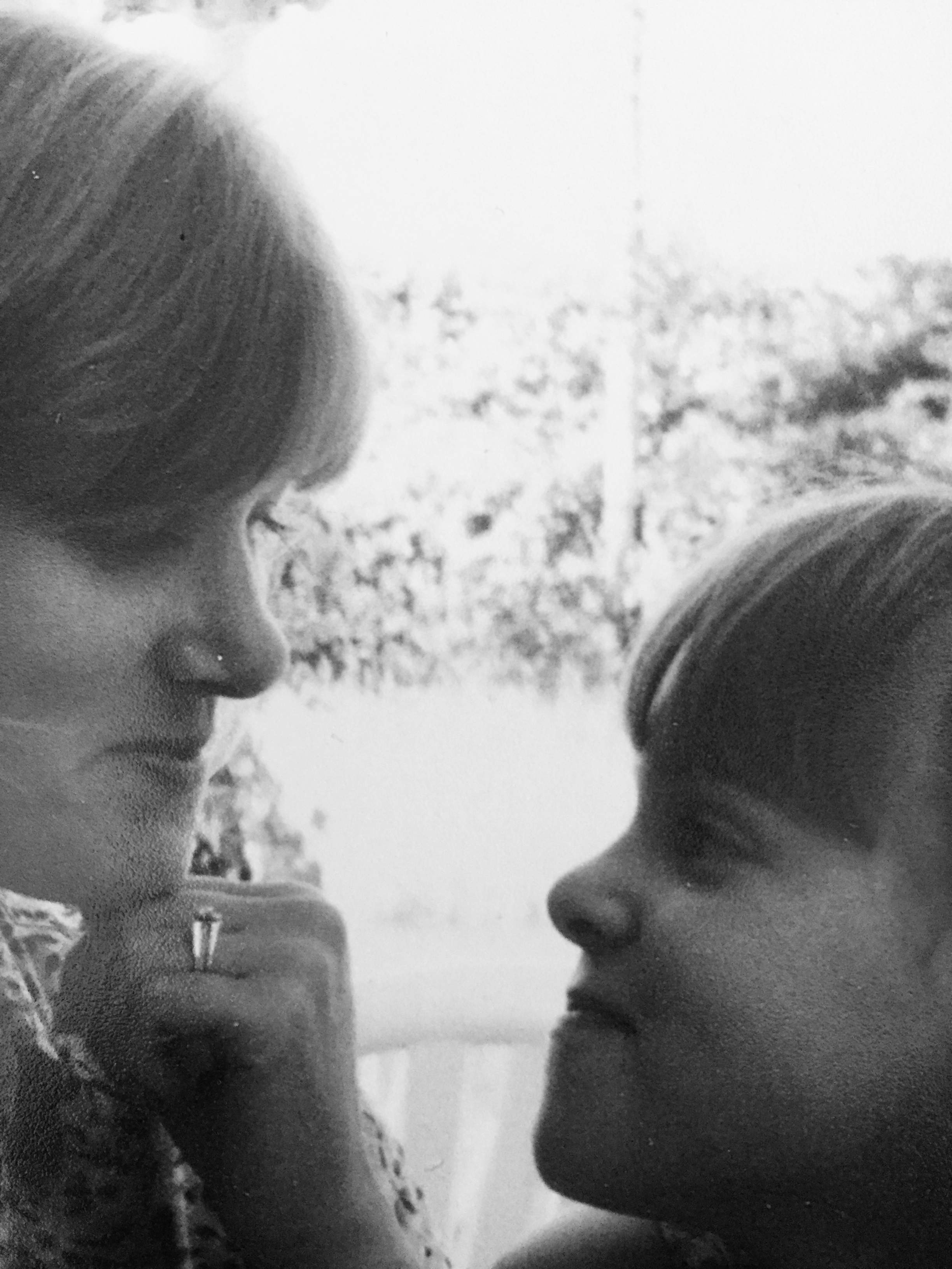 Black-and-white childhood photo of the writer and her mother, smiling at each other.