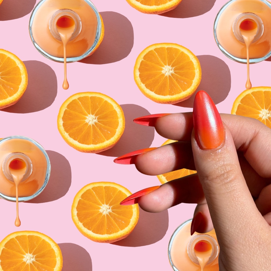 a pink background with oranges and a hand wearing orange nail polish