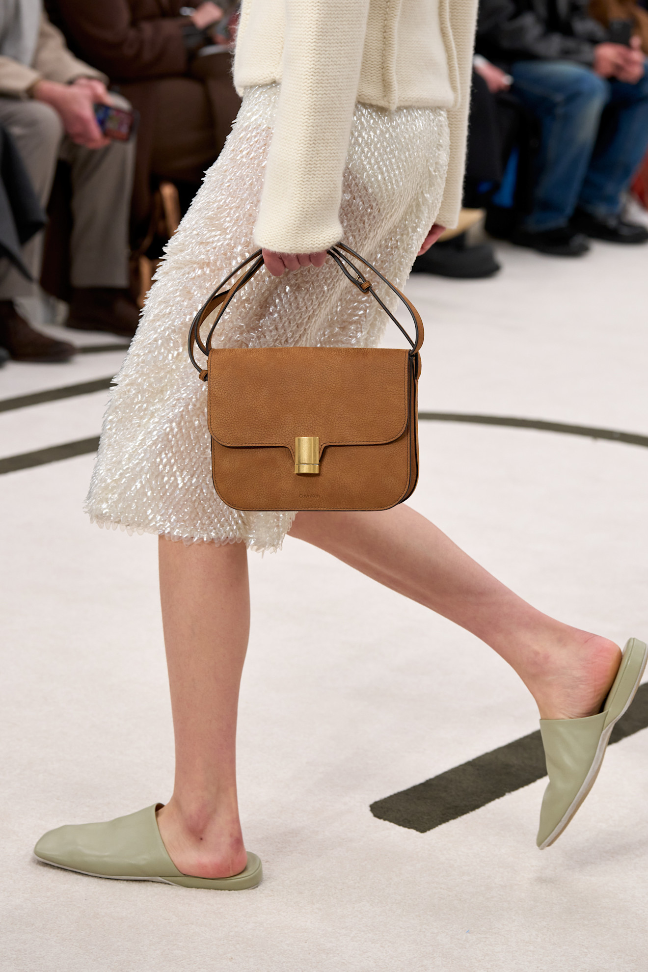 a woman carrying a brown suede crossbody bag at Calvin Klein Fall 2025 runway show