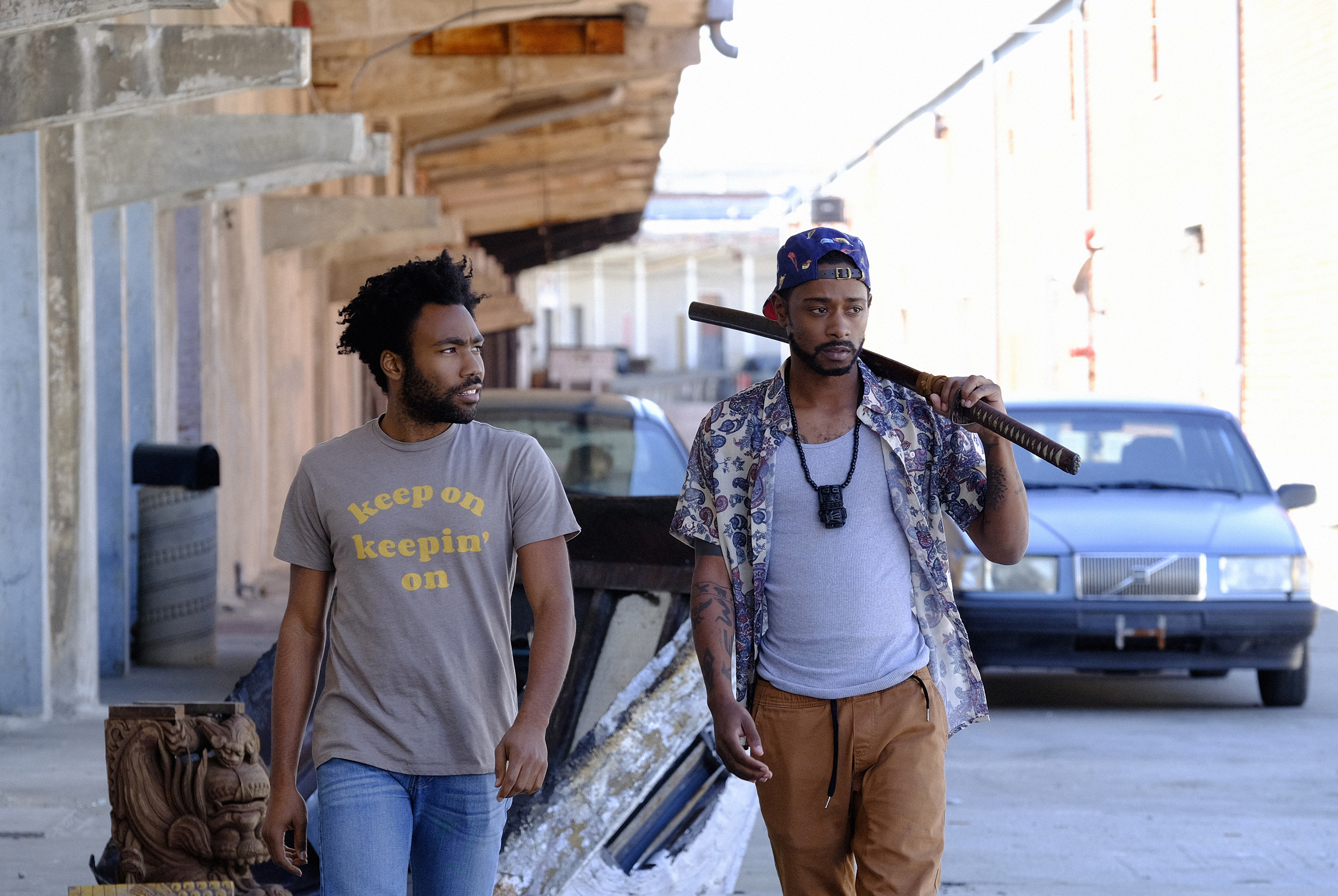 donald glover and lakeith stanfield walking through the street and holding a bat in Atlanta