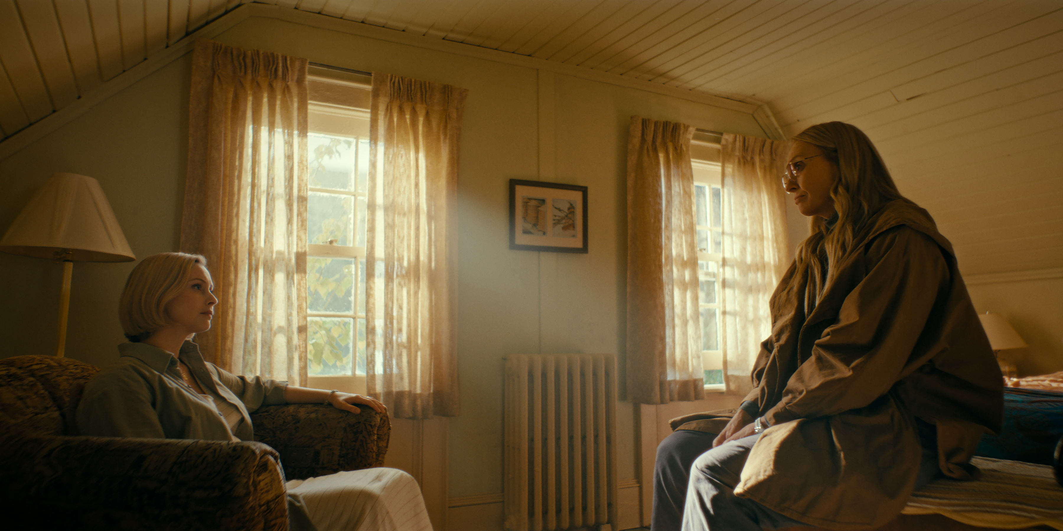 sarah gordon as laura sitting in a chair across from toni collette as evelyn in wayward