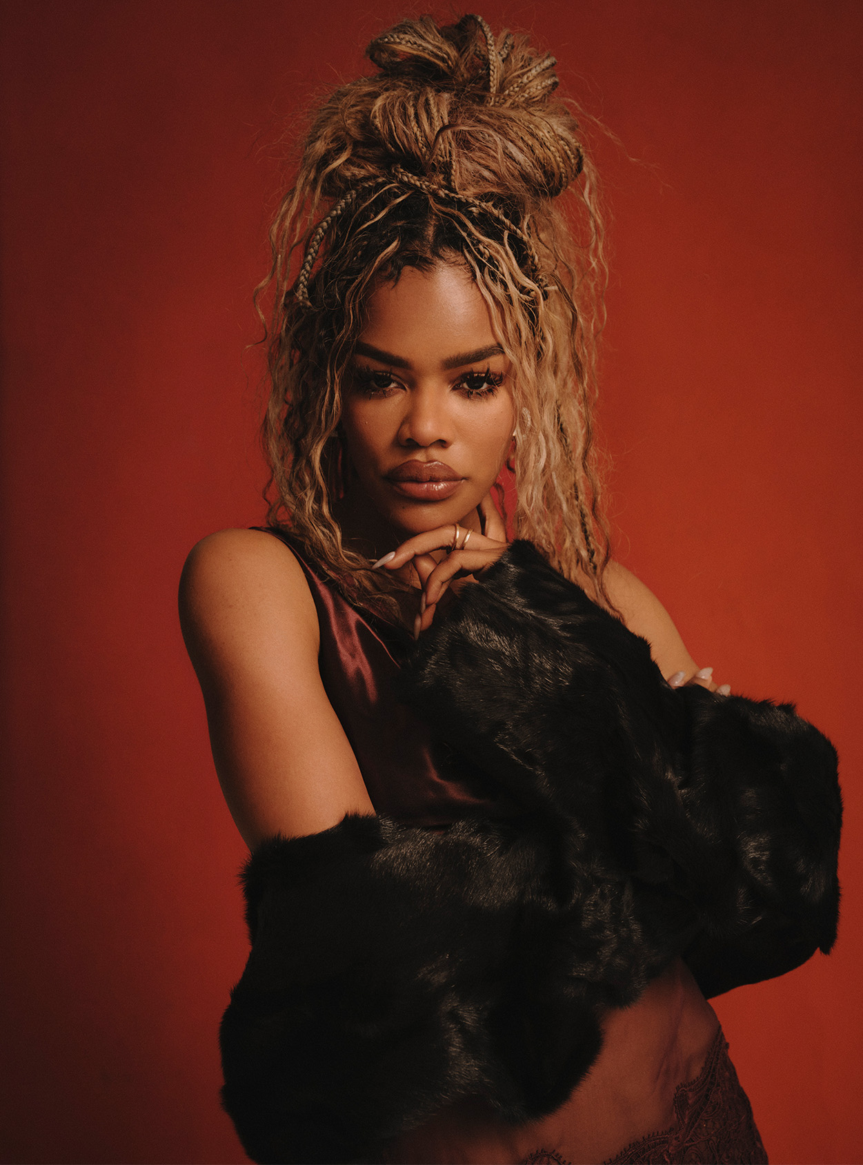 Teyana Taylor staring at the camera with a black jacket around her lower arms