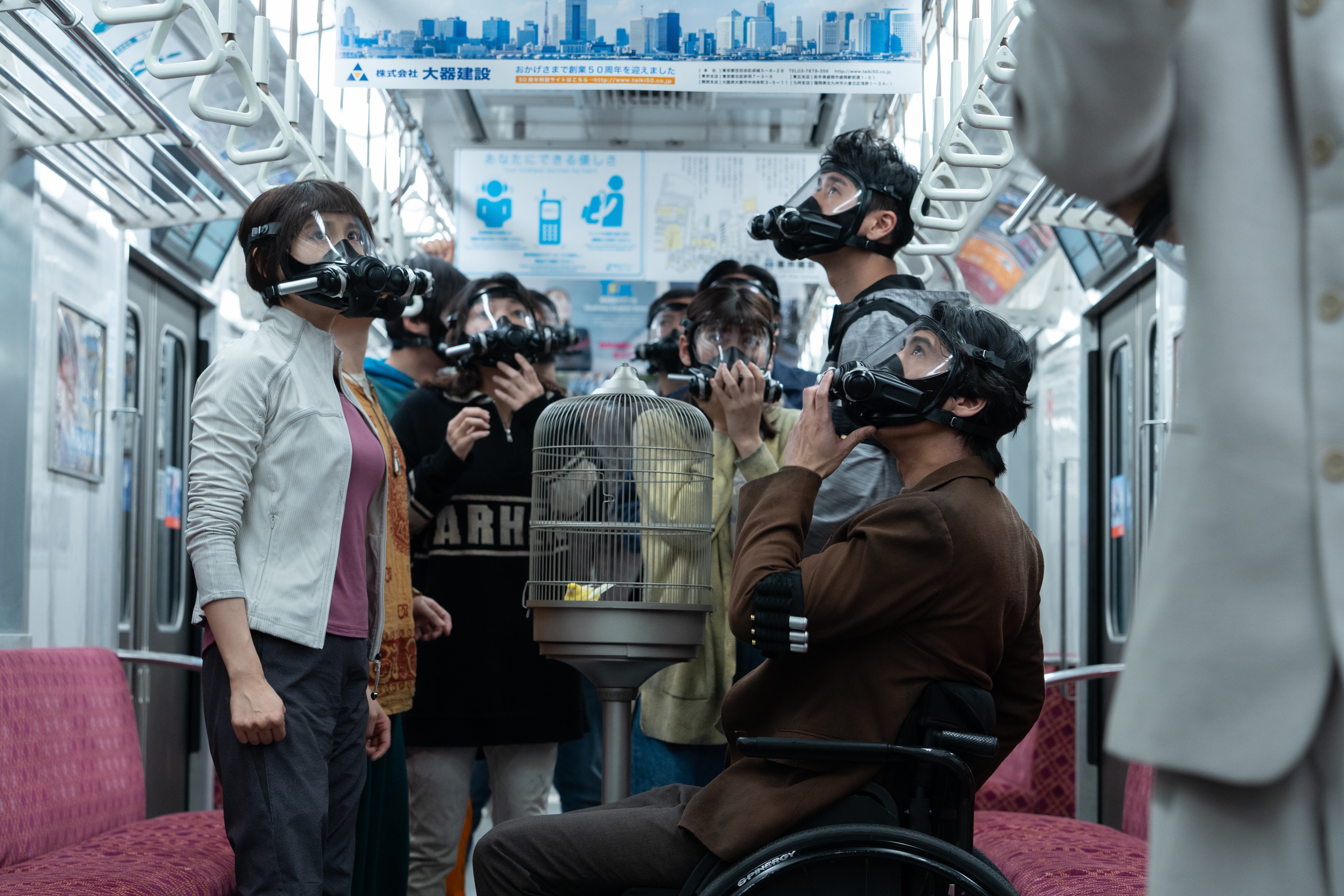 A group of people wearing gas masks stand in a Japanese subway train, in 'Alice in Borderland' season 3.