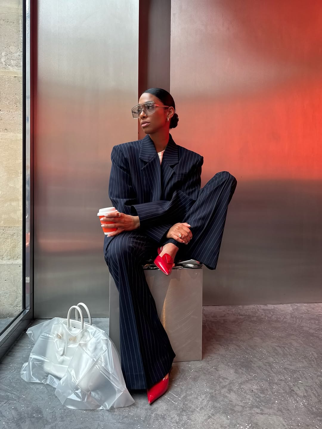 @cherifaakili wears navy striped suit and red heels