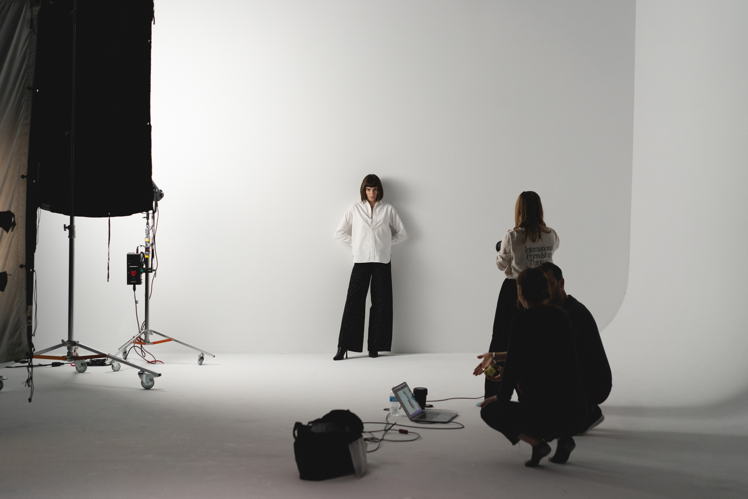 a model stands in front of a blank wall on set with the brand Unspun