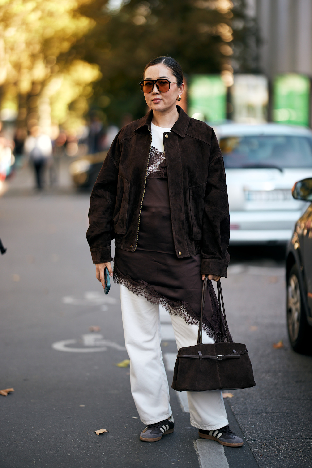 woman wearing a jacket, t-shirt, lace dress, pants, and sneakers