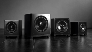 Alll four Wharfedale Nova subwoofers on a gradient grey background and dark reflective surface