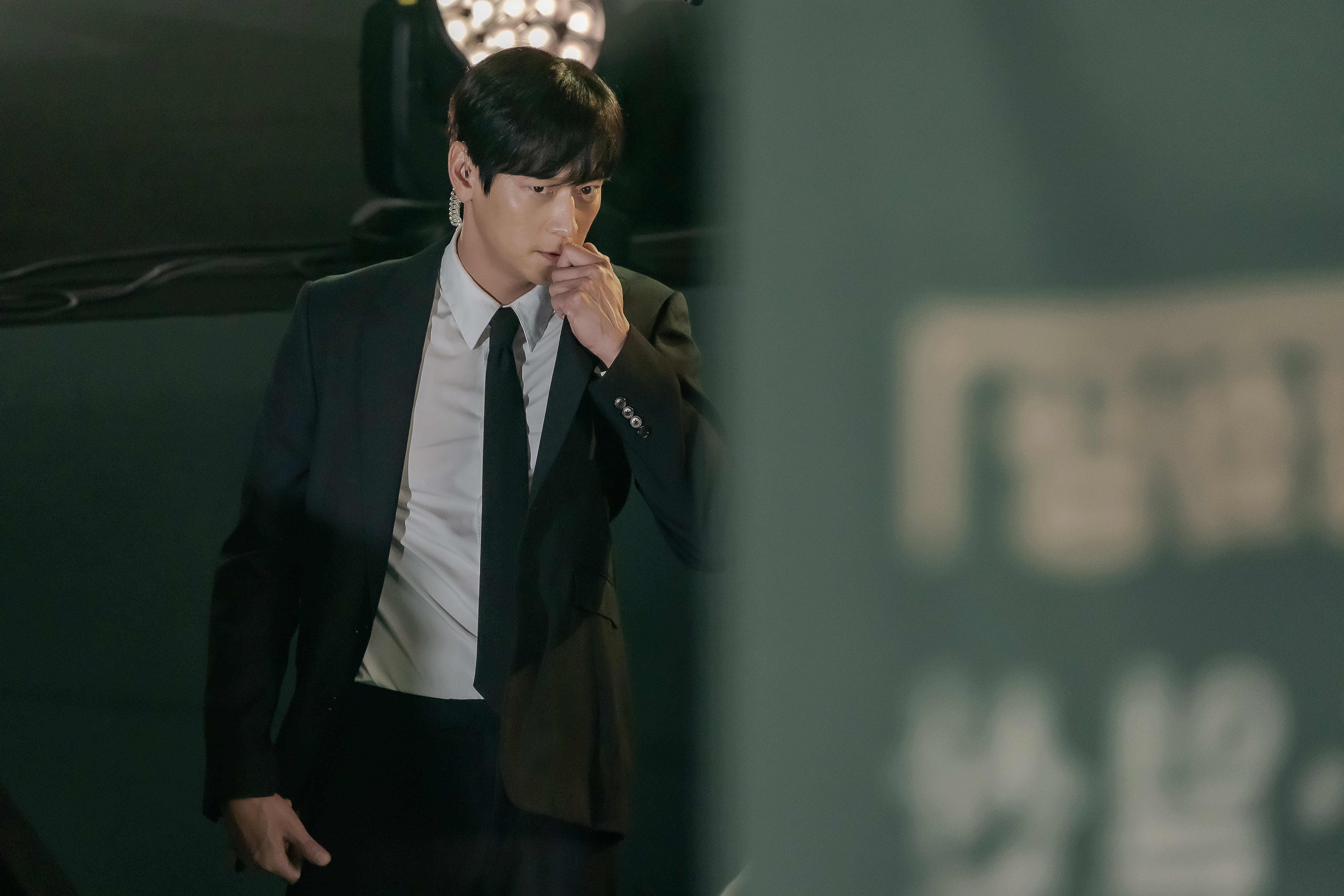 Gang Dong-won talks into an earpiece and wears a suit in 'Tempest.'
