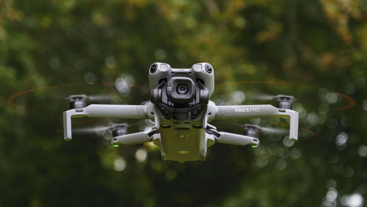 DJI Mini 5 Pro in flight with trees in the background