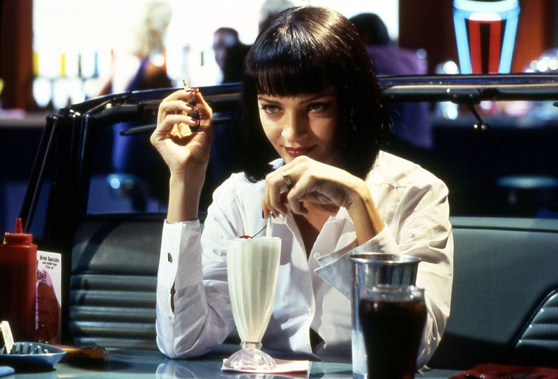 uma thurman as mia wallace drinking a milk shake in pulp fiction