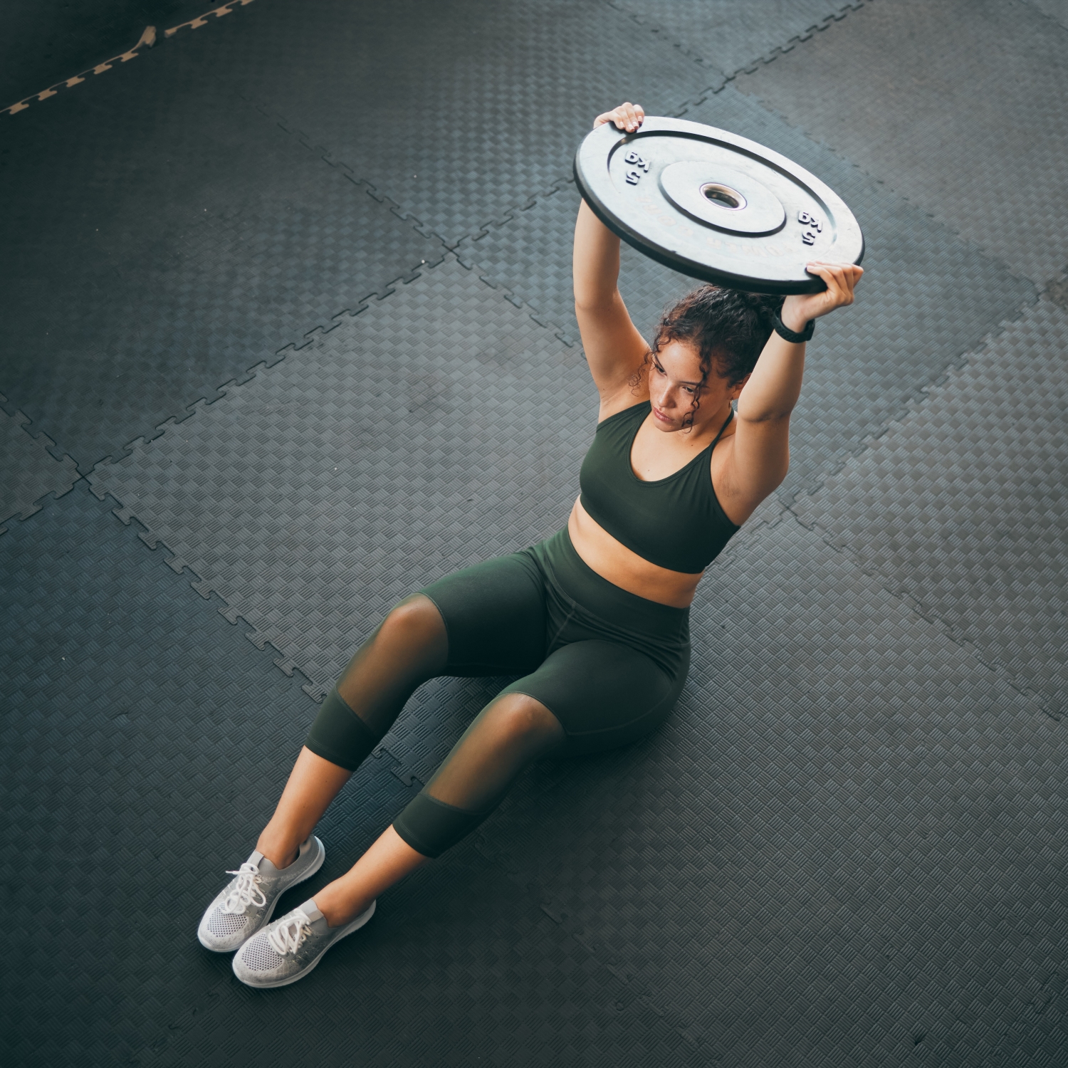 Woman exercising with weight above her head