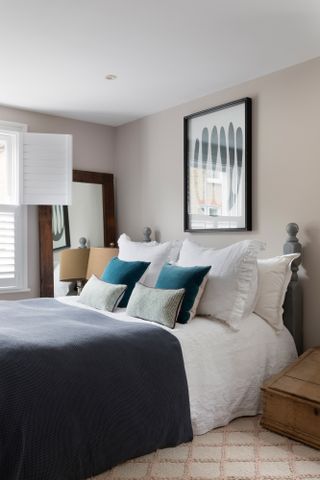 Pippa Jones house: bedroom with beige-pink walls, big monochrome abstract print, white bedding and dark grey throw