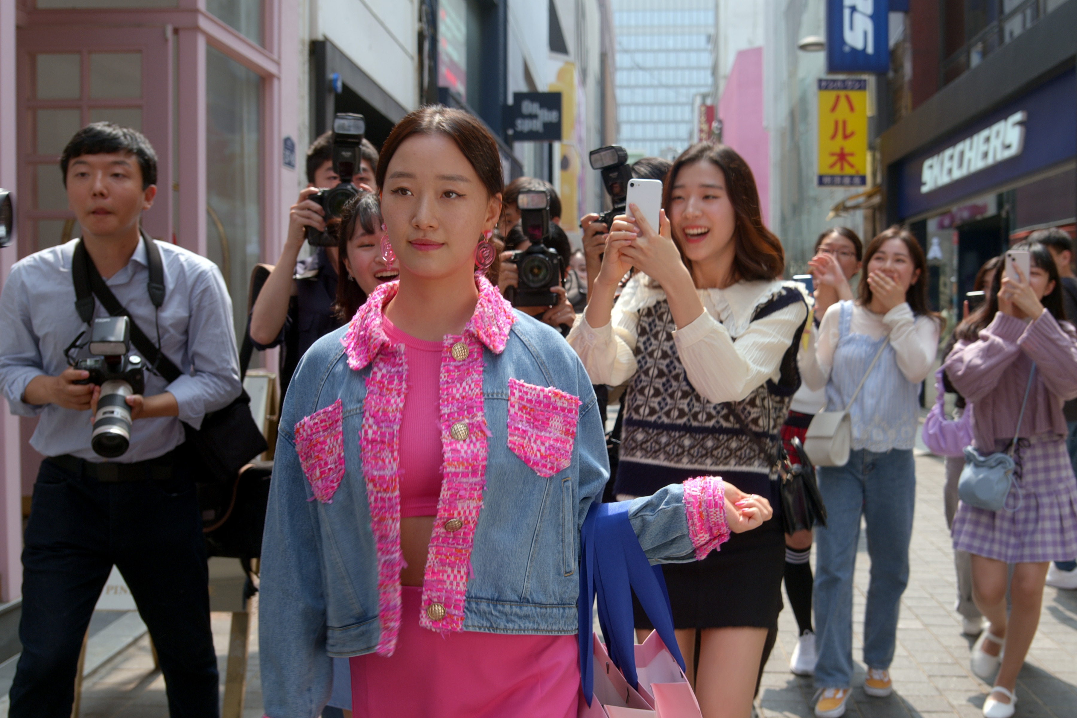 gia kim waering a pink and denim jacket walking through seoul in xo kitty