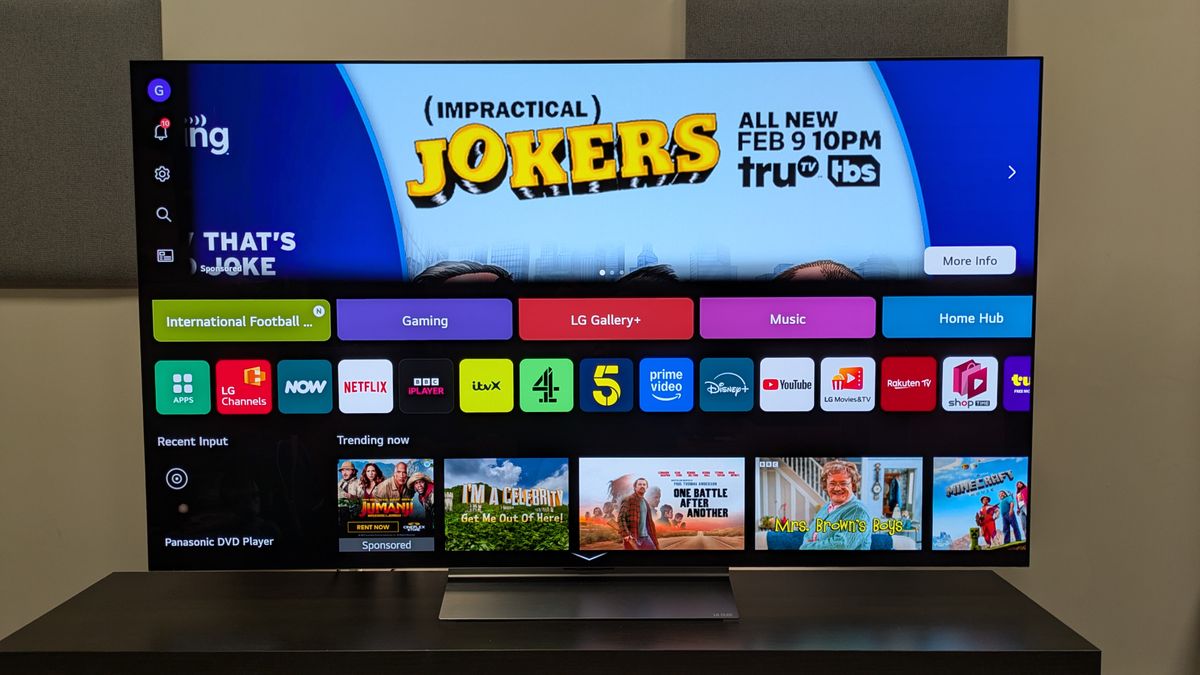 The LG C6 OLED TV with the webOS 26 home page on screen. Apps are well laid out but there is a large banner ad at the top of the screen