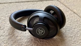 The jlab jbuds open wireless headphones pictured on a stone surface