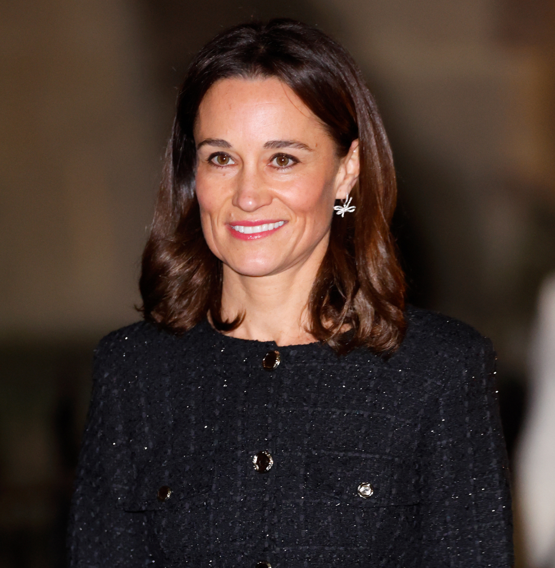 Pippa Middleton wearing a black tweed outfit and smiling