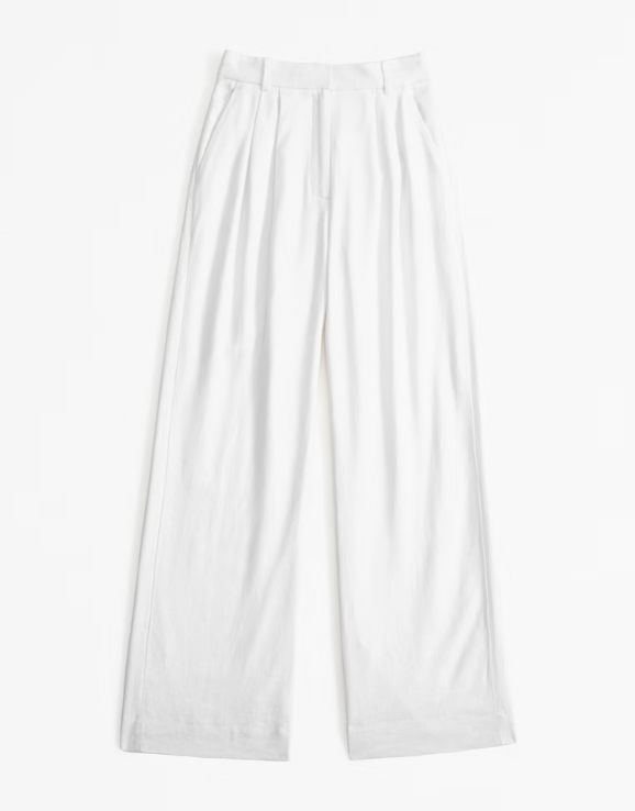 a pair of white pants in front of a plain backdrop