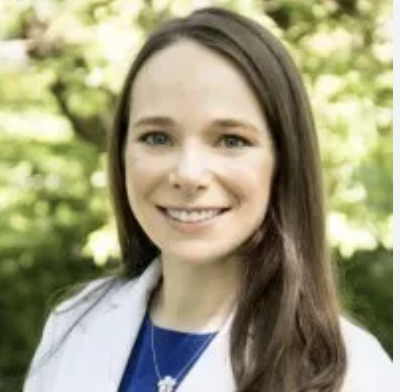 a woman with light brown hair in a white lab coat
