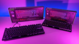 Low-angle shot of Razer Huntsman V3 HE TKL and Mini 65% keyboards with RGB backlighting placed in front of their retail packaging.