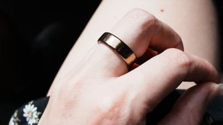 A close up of a hand wearing the Oura Ring 5