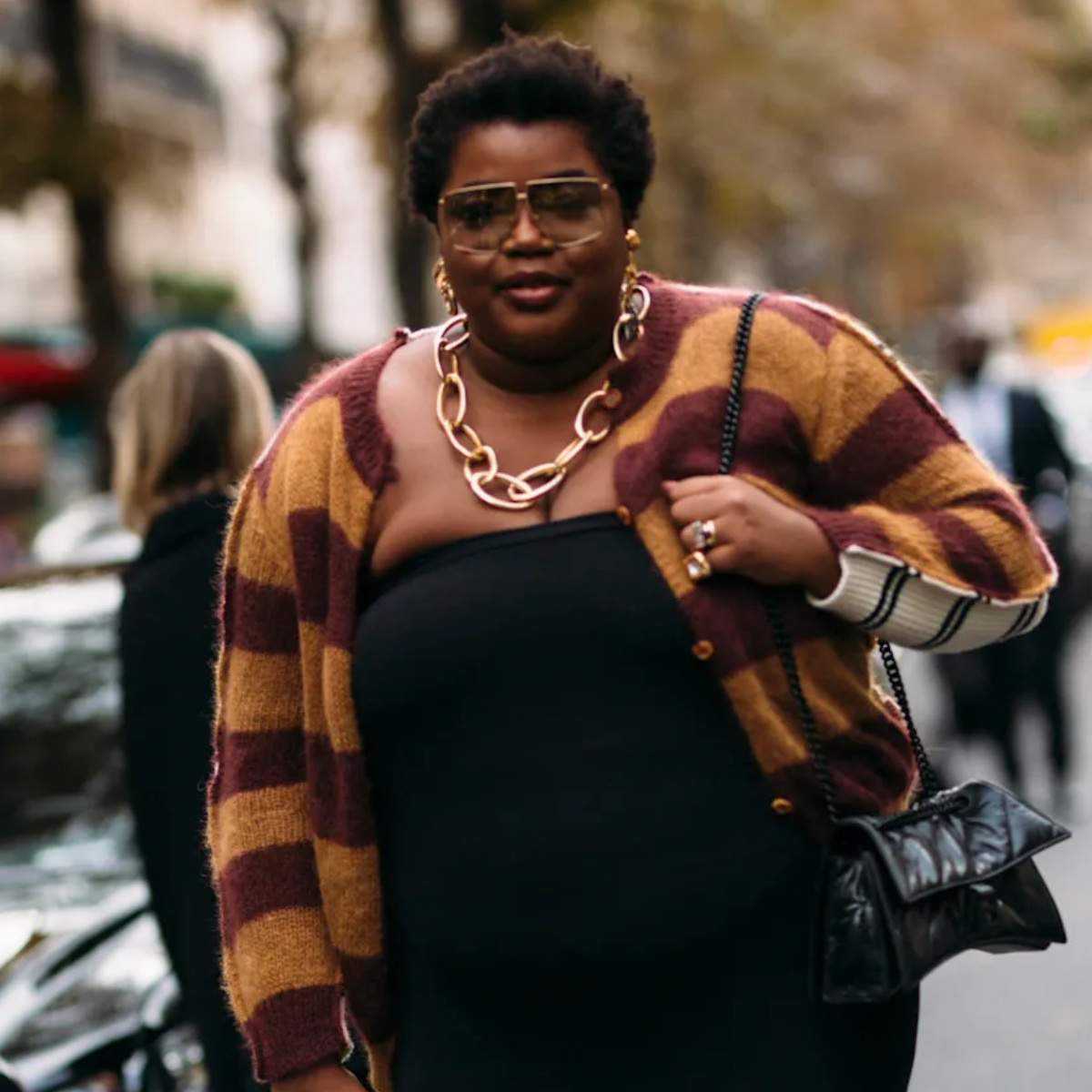 woman wearing a striped sweater and a chunky gold necklace. 