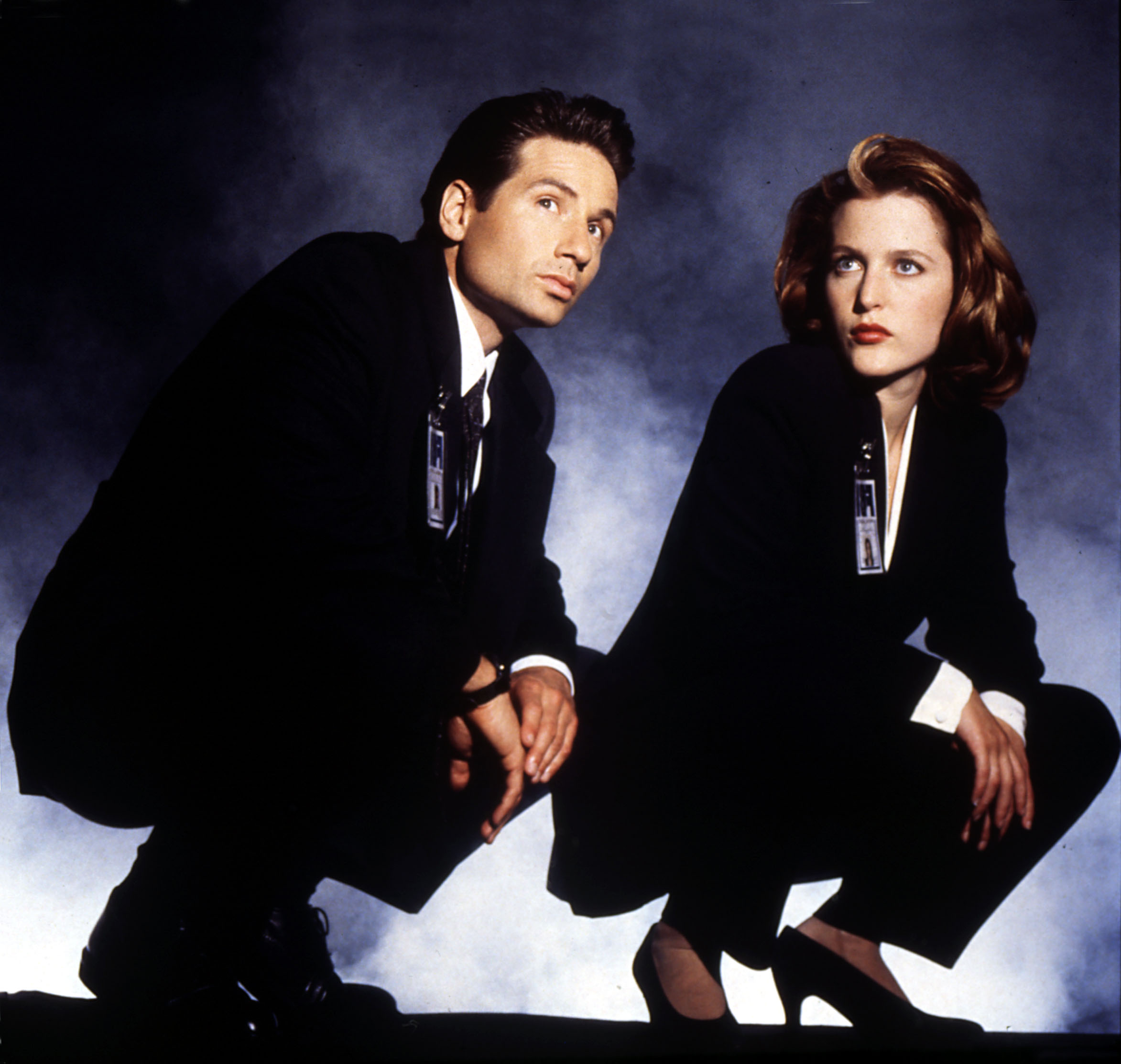 a promotional shot of sculder and mully squatting down for the X Files