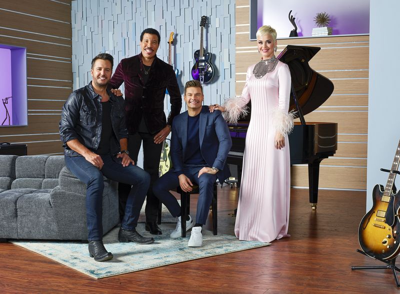 American Idol judges luke bryan katy perry lionel richie and host ryan seacrest sitting around a music studio