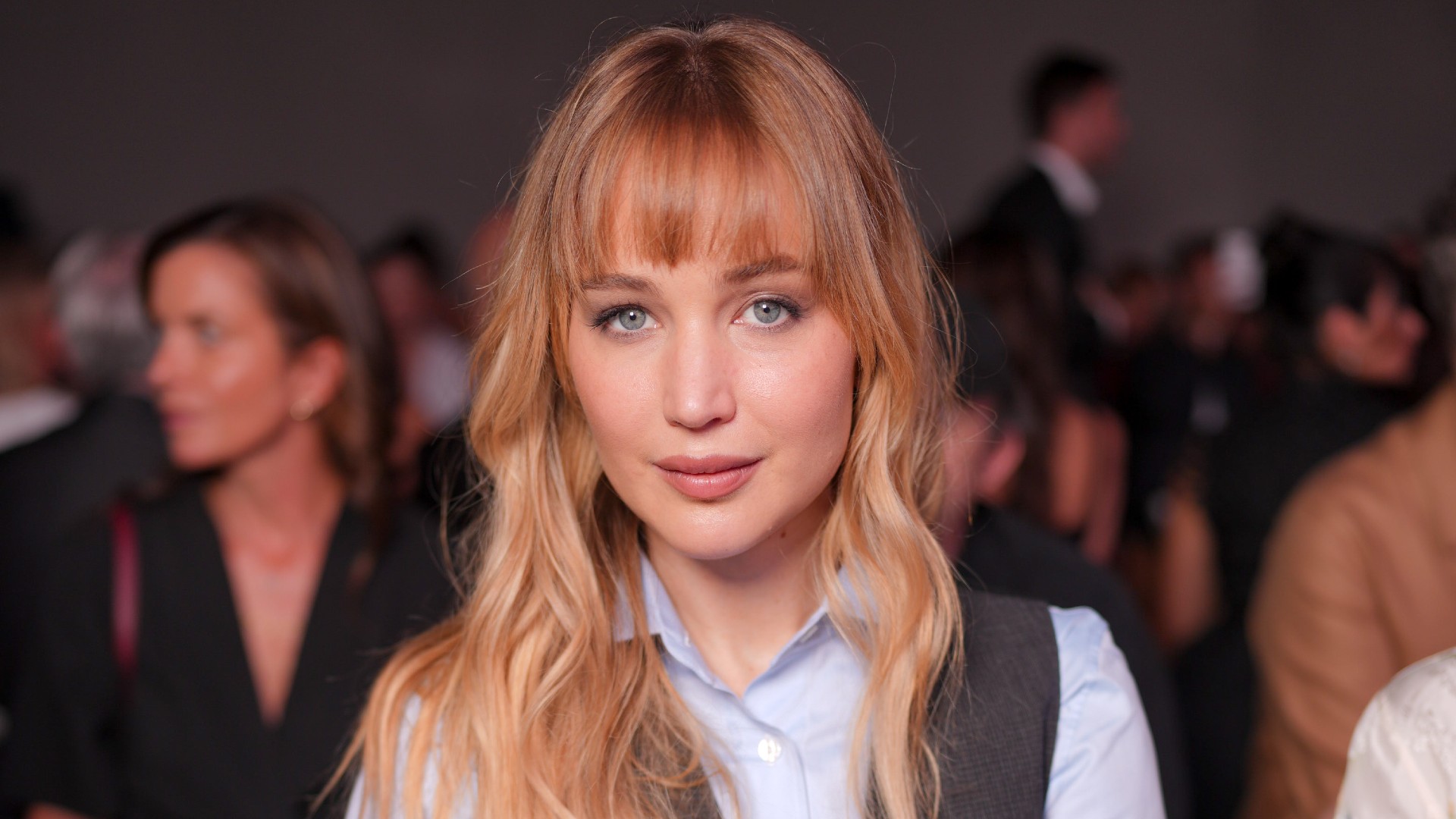 a white woman with dark blonde hair sitting front row at a fashion show