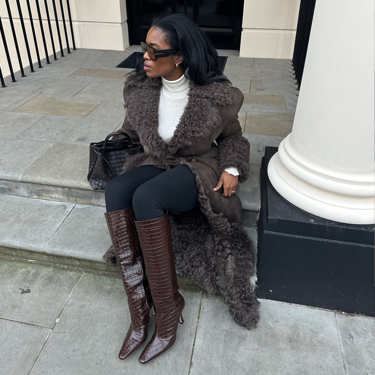 @nlmarilyn wears brown knee-high boots shearling coat and black leggings